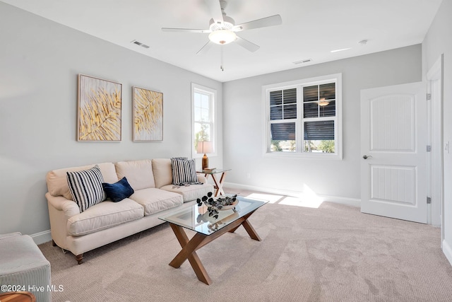 carpeted living area with visible vents, baseboards, and a ceiling fan