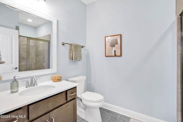 full bath featuring vanity, baseboards, tile patterned floors, toilet, and tiled shower
