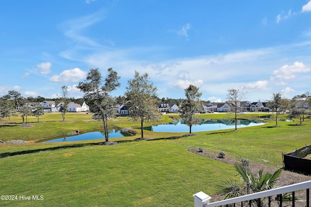 view of home's community featuring a water view, a residential view, and a lawn