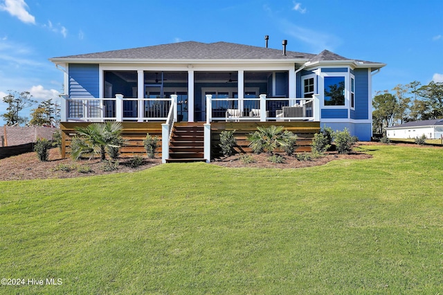rear view of property with roof with shingles, stairway, a sunroom, and a lawn