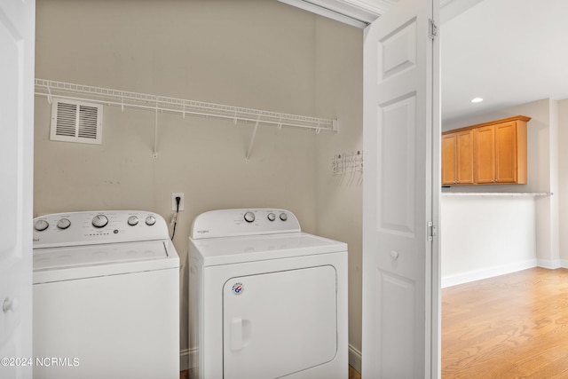 laundry room featuring independent washer and dryer and hardwood / wood-style floors