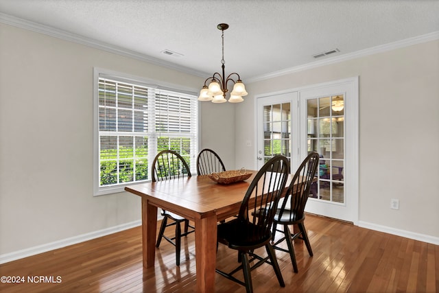 dining area with a textured ceiling, dark hardwood / wood-style flooring, and an inviting chandelier