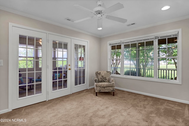 sitting room featuring light carpet, plenty of natural light, ornamental molding, and ceiling fan