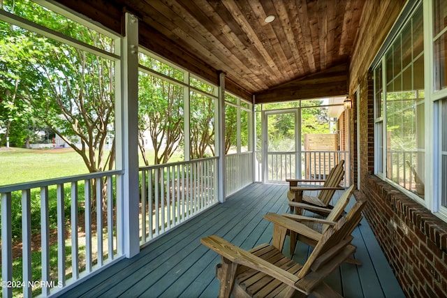 unfurnished sunroom featuring vaulted ceiling and wooden ceiling