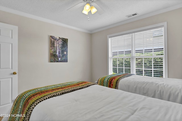 bedroom featuring a textured ceiling, ceiling fan, and crown molding