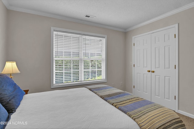 bedroom with carpet, ornamental molding, a textured ceiling, and a closet