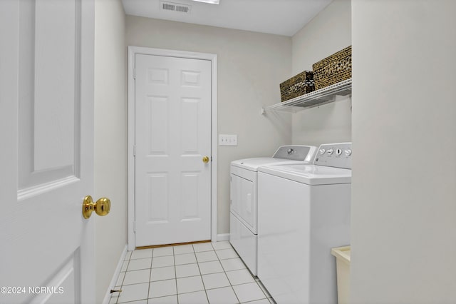 laundry room featuring light tile patterned flooring and washing machine and clothes dryer