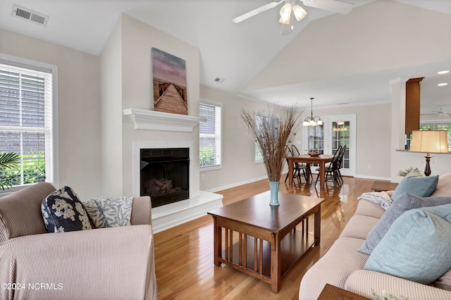 living room featuring a fireplace, ceiling fan, light hardwood / wood-style flooring, and high vaulted ceiling