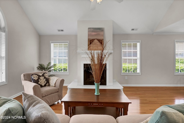 living room featuring ceiling fan, a healthy amount of sunlight, light hardwood / wood-style floors, and vaulted ceiling