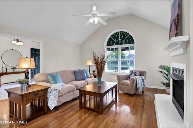 living room featuring a tile fireplace, hardwood / wood-style floors, ceiling fan, and lofted ceiling