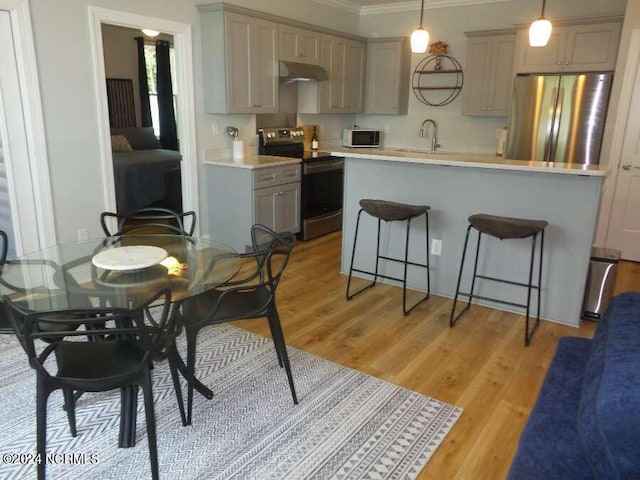 interior space with light hardwood / wood-style flooring, hanging light fixtures, range with electric cooktop, stainless steel fridge, and ornamental molding