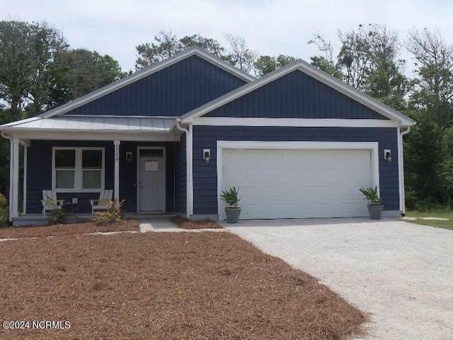 view of front of house featuring aphalt driveway, covered porch, and an attached garage