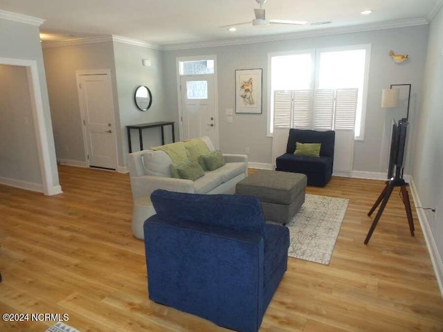 living room with light hardwood / wood-style floors, ornamental molding, and ceiling fan