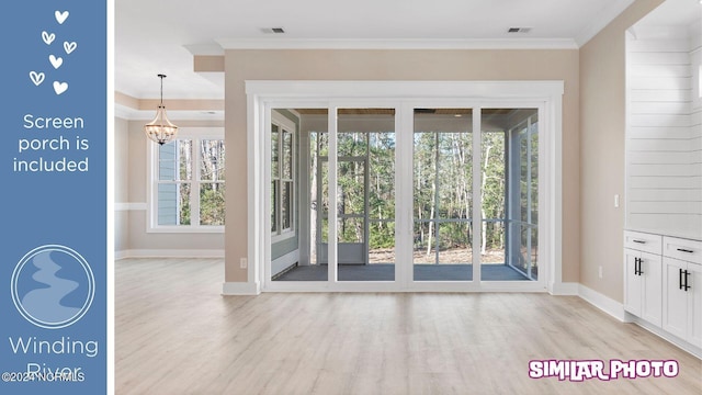 doorway to outside with a healthy amount of sunlight, light hardwood / wood-style floors, an inviting chandelier, and crown molding