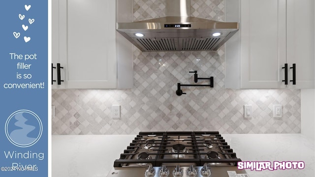 kitchen featuring tasteful backsplash, white cabinets, wall chimney range hood, and gas cooktop