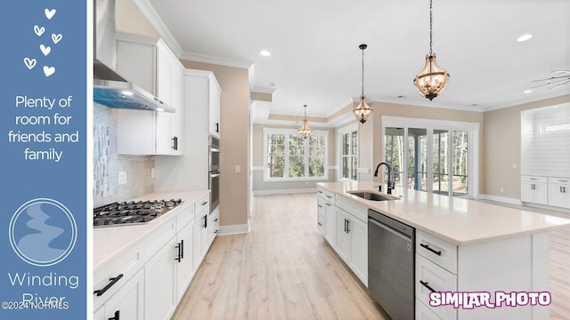 kitchen featuring a kitchen island with sink, sink, a notable chandelier, white cabinetry, and stainless steel appliances