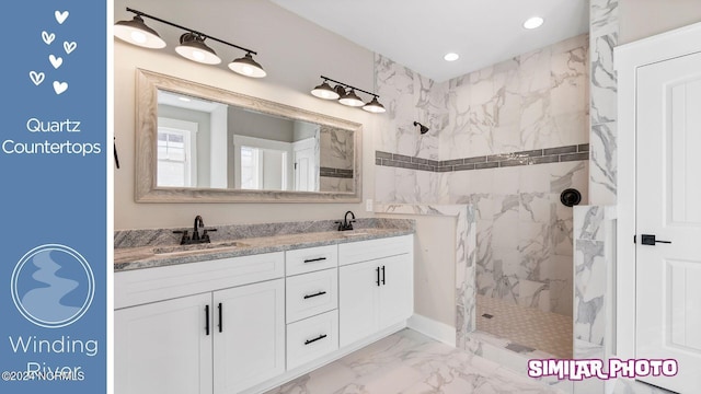 bathroom with tiled shower and vanity