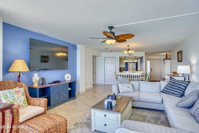 tiled living room featuring ceiling fan with notable chandelier