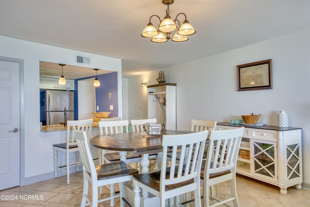 dining area featuring an inviting chandelier and light tile patterned floors