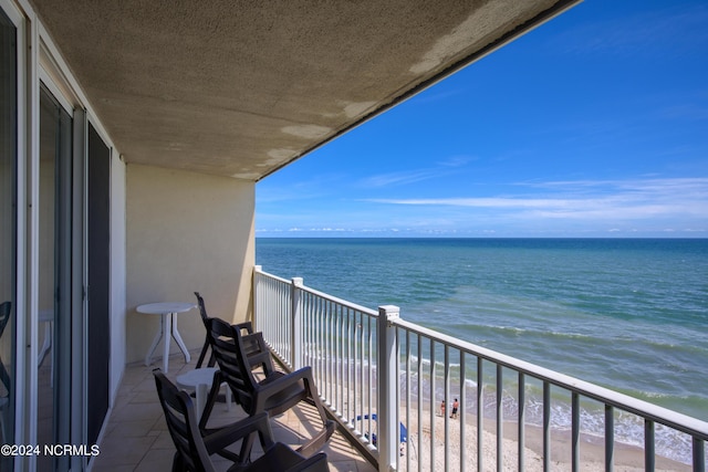 balcony featuring a water view and a view of the beach