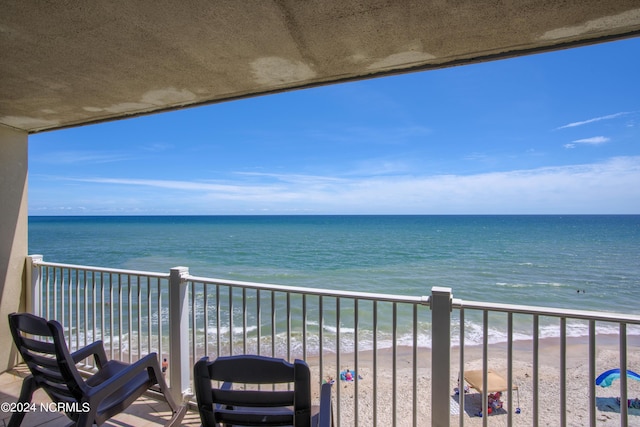 balcony with a water view and a beach view