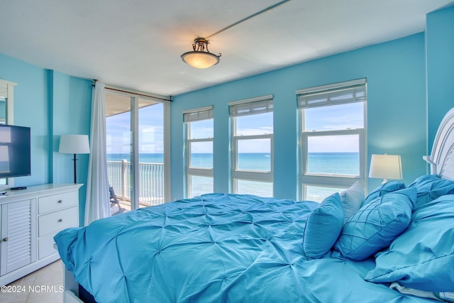 tiled bedroom featuring a water view and access to exterior