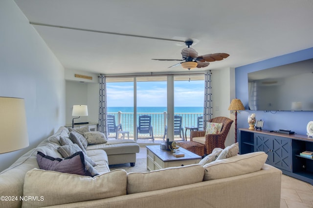 tiled living room featuring ceiling fan and a wall of windows