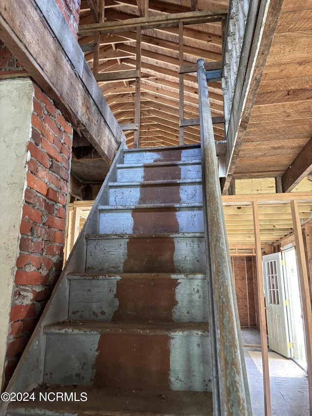 stairway featuring brick wall