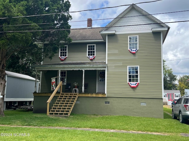 rear view of house featuring a yard