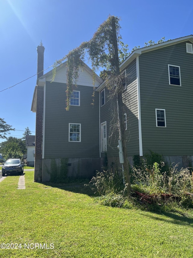 rear view of property with a yard and a chimney