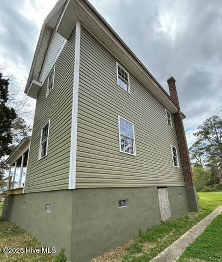 view of home's exterior featuring a chimney and crawl space