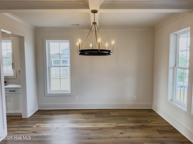 unfurnished dining area with ornamental molding, dark wood-type flooring, and an inviting chandelier