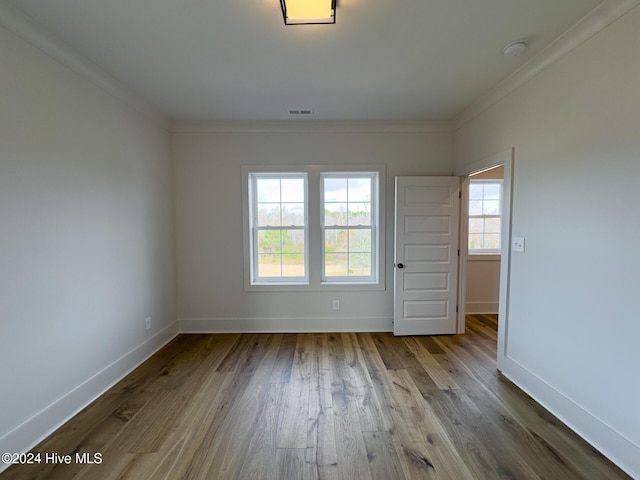 spare room featuring hardwood / wood-style floors and ornamental molding