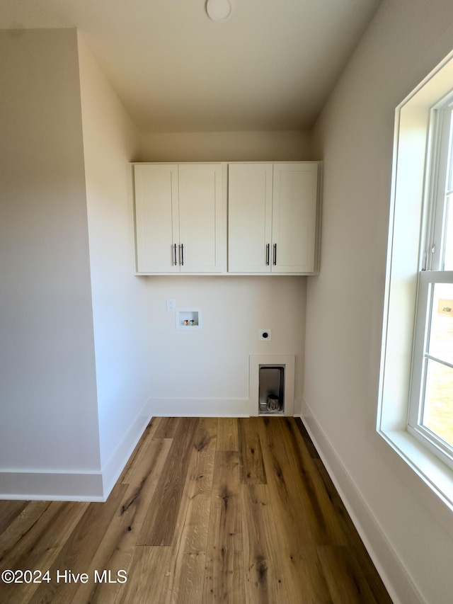 washroom with hookup for an electric dryer, cabinets, dark wood-type flooring, and hookup for a washing machine