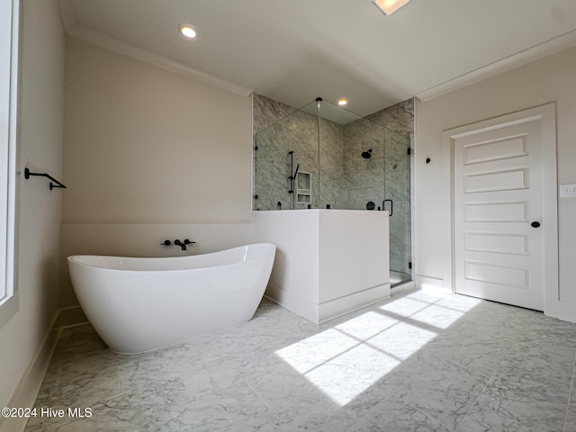 bathroom featuring ornamental molding and independent shower and bath