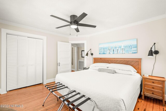 bedroom with ceiling fan, ornamental molding, light hardwood / wood-style flooring, and a closet