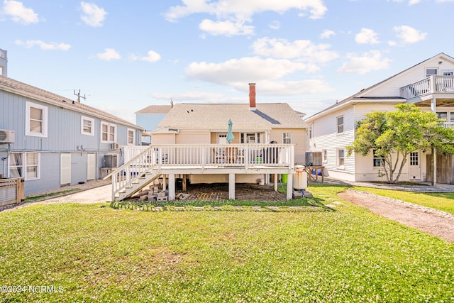 rear view of house featuring a deck and a yard