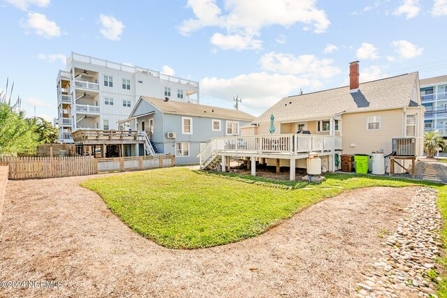 rear view of property featuring a lawn and a wooden deck