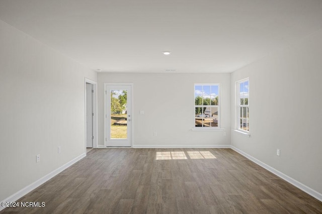 empty room featuring dark hardwood / wood-style flooring and a healthy amount of sunlight