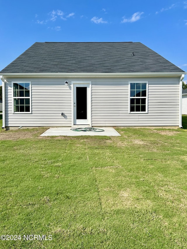 rear view of property with a lawn and a patio