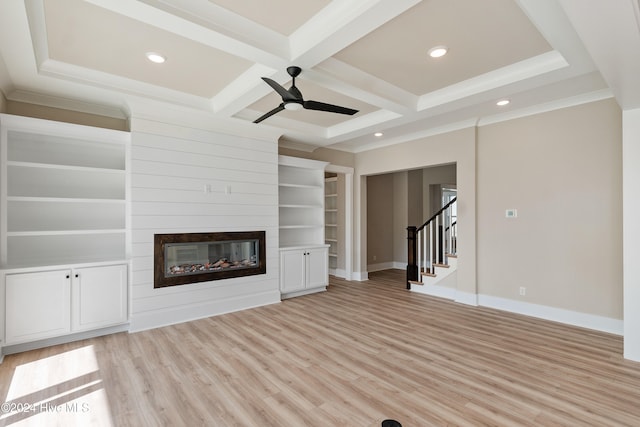 unfurnished living room featuring beamed ceiling, ceiling fan, a large fireplace, coffered ceiling, and light wood-type flooring