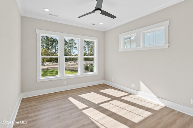 spare room with ornamental molding, light wood-type flooring, and ceiling fan