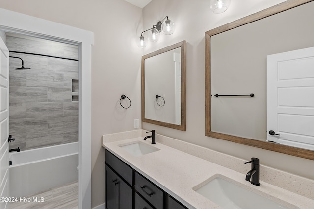 full bathroom with hardwood / wood-style floors, vanity, toilet, and tiled shower / bath