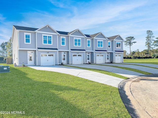 view of property featuring a garage and a front lawn