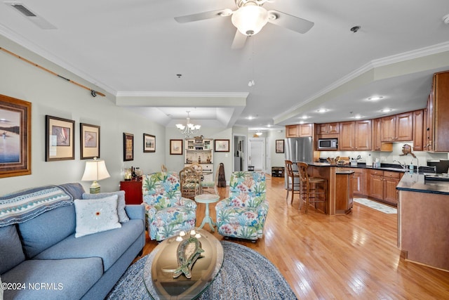 living room with sink, light wood-type flooring, ceiling fan with notable chandelier, and ornamental molding