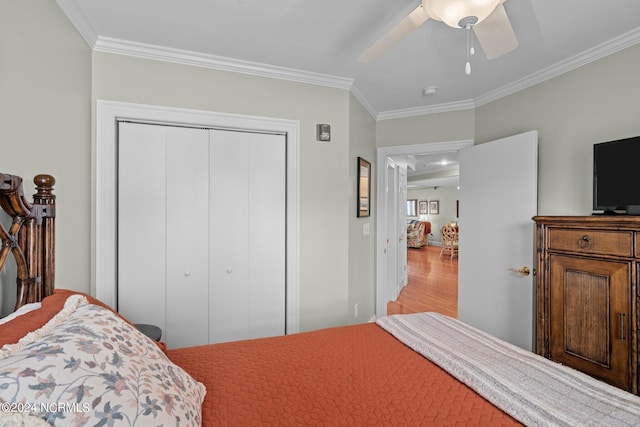 bedroom with ceiling fan, ornamental molding, and a closet