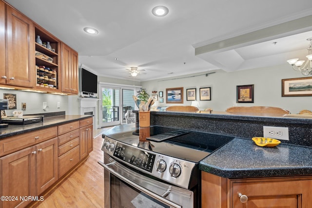 kitchen with stainless steel range with electric cooktop, light hardwood / wood-style floors, a kitchen island, ceiling fan with notable chandelier, and ornamental molding