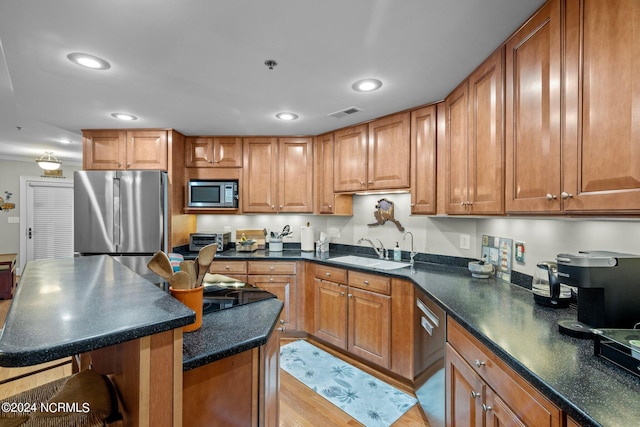 300 Midyette St Unit A8, Oriental, NC 28571 - kitchen featuring appliances with stainless steel finishes, a sink, dark countertops, brown cabinets, and recessed lighting