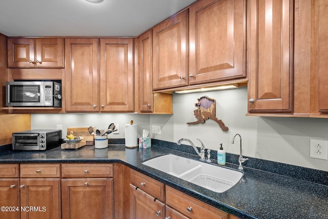 300 Midyette St Unit A8, Oriental, NC 28571 - kitchen featuring stainless steel microwave, a sink, brown cabinetry, and dark stone countertops