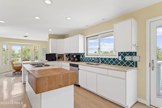 kitchen with tasteful backsplash, sink, white cabinets, and appliances with stainless steel finishes